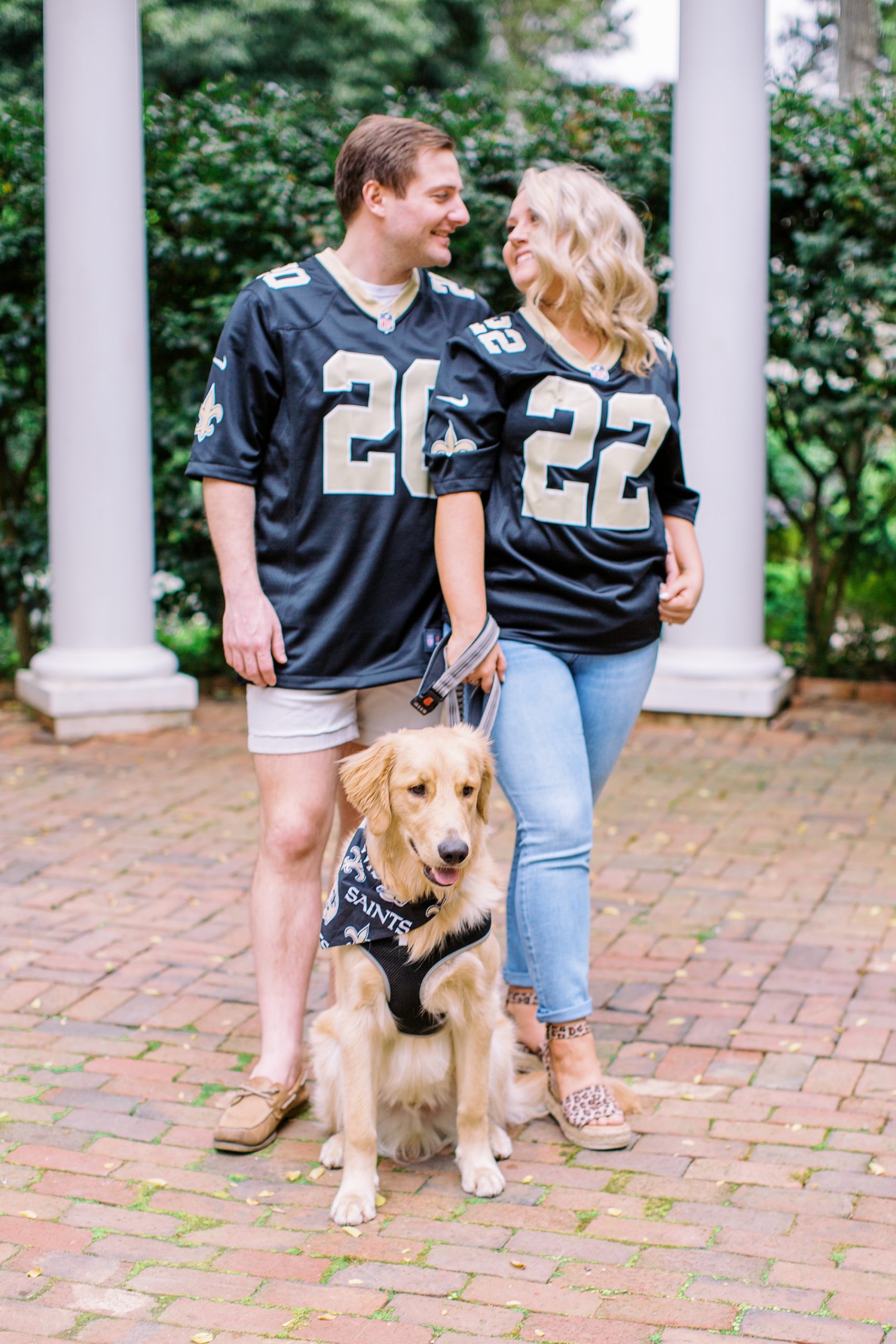 couple poses with dog in custom jerseys