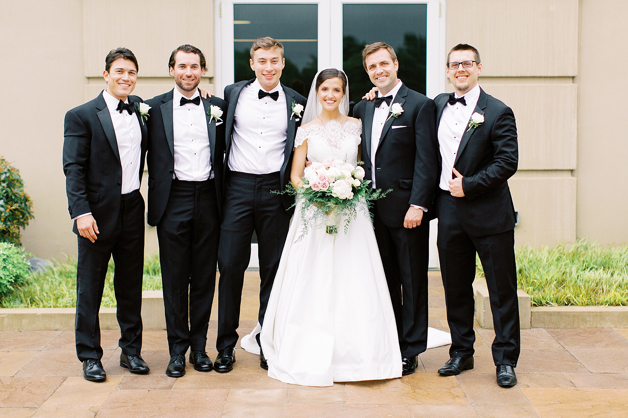 bride poses with groomsmen