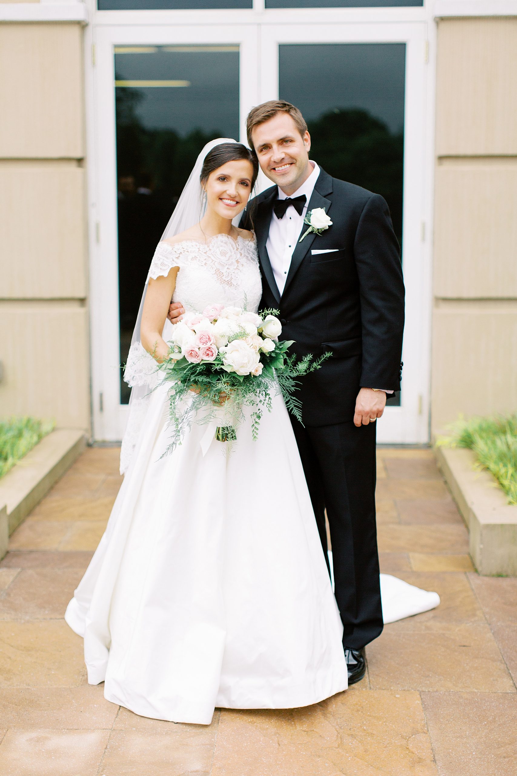 bride and groom lean in together outside Ballantyne Country Club