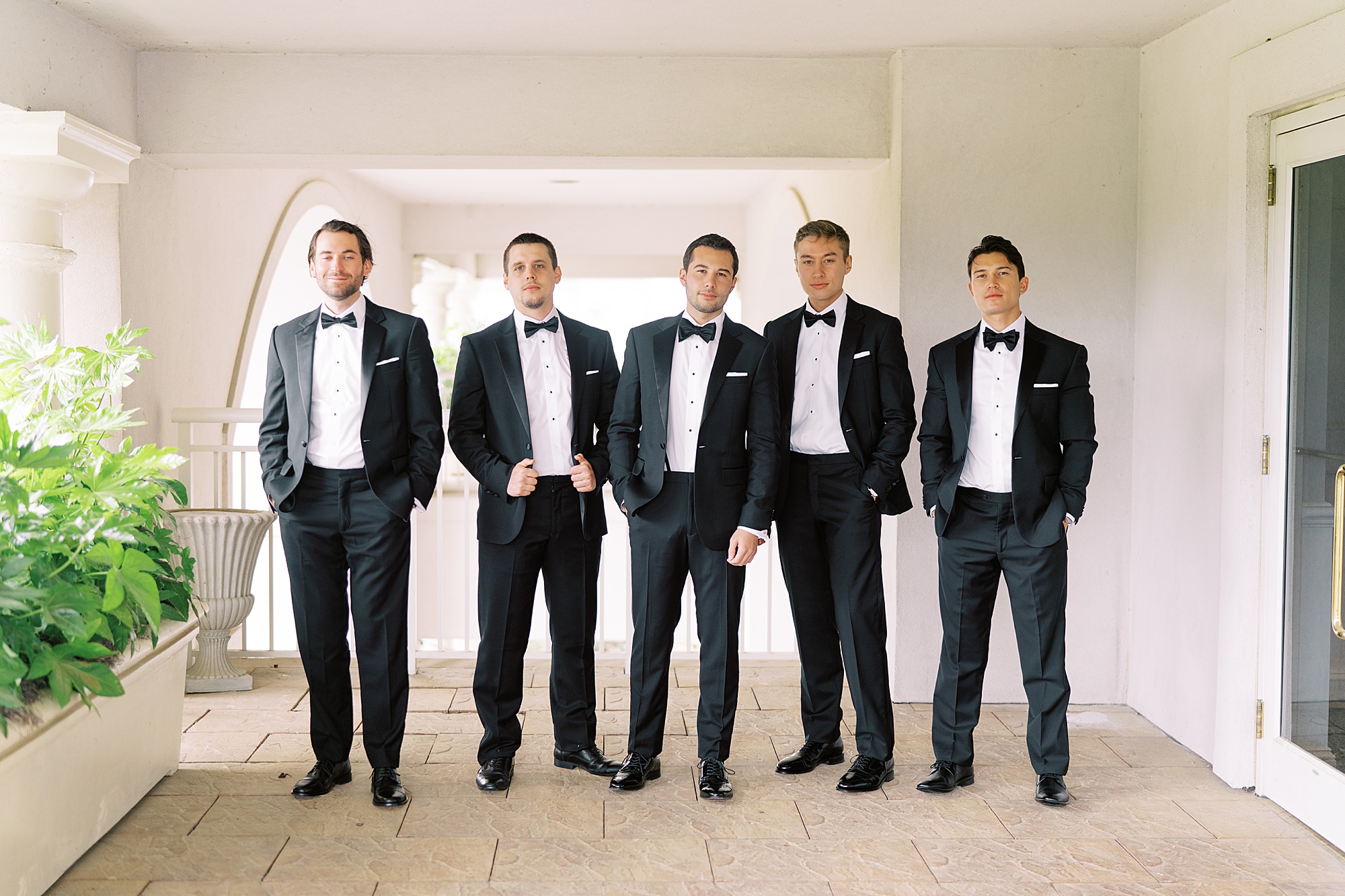 groom and groomsmen pose together outside Ballantyne Country Club