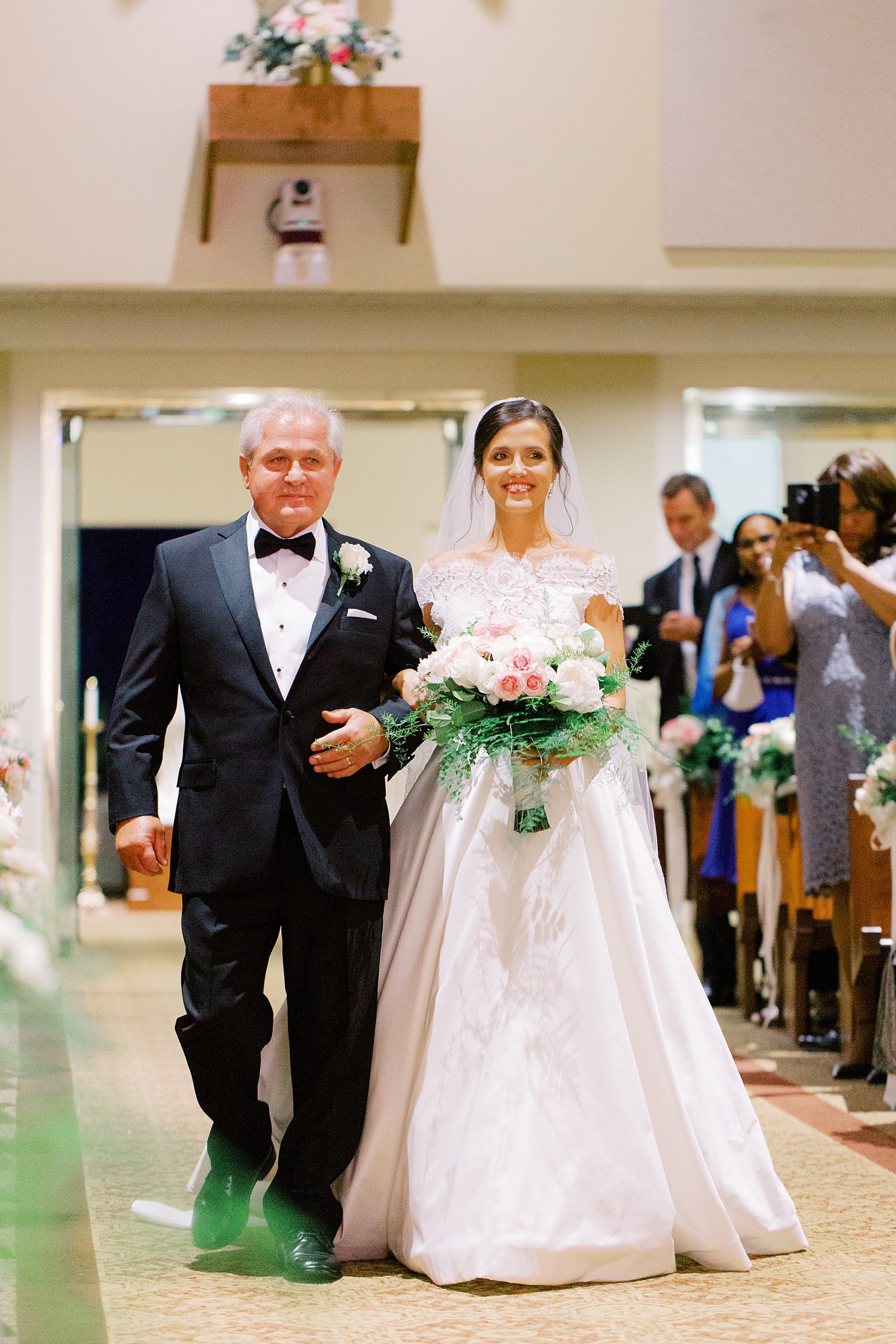 bride and father walk into church during traditional church wedding in Charlotte NC