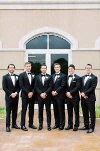 groom and groomsmen pose together outside Ballantyne Country Club