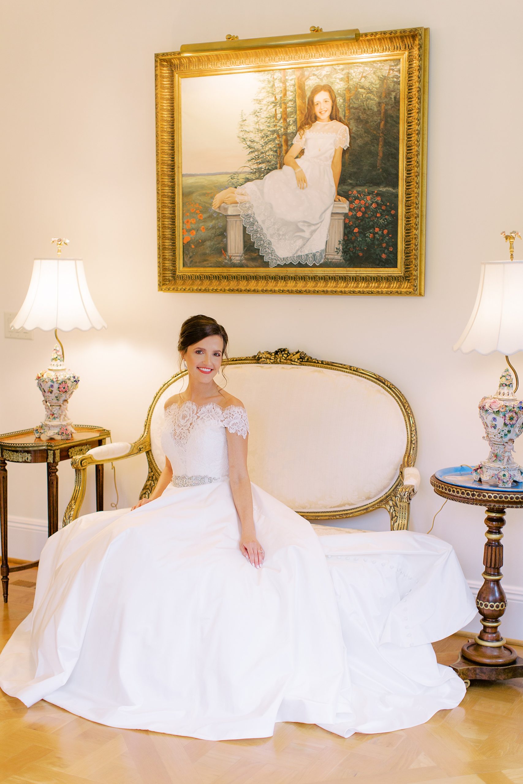 bride sits under portrait at Ballantyne Country Club