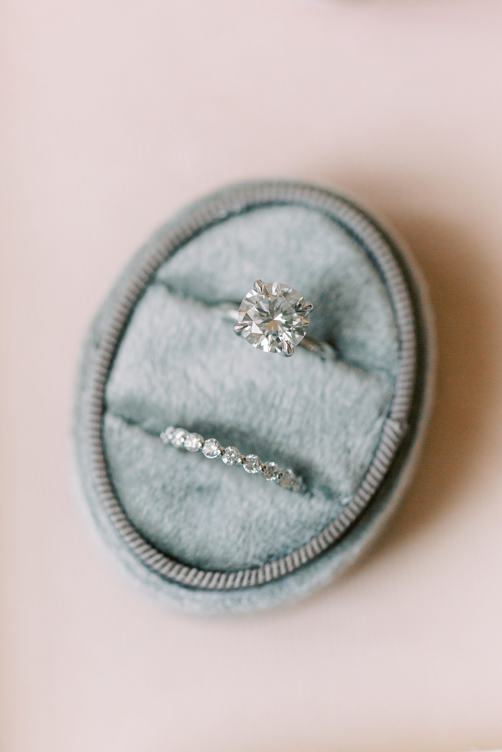 bride's wedding rings rest in blue ring box
