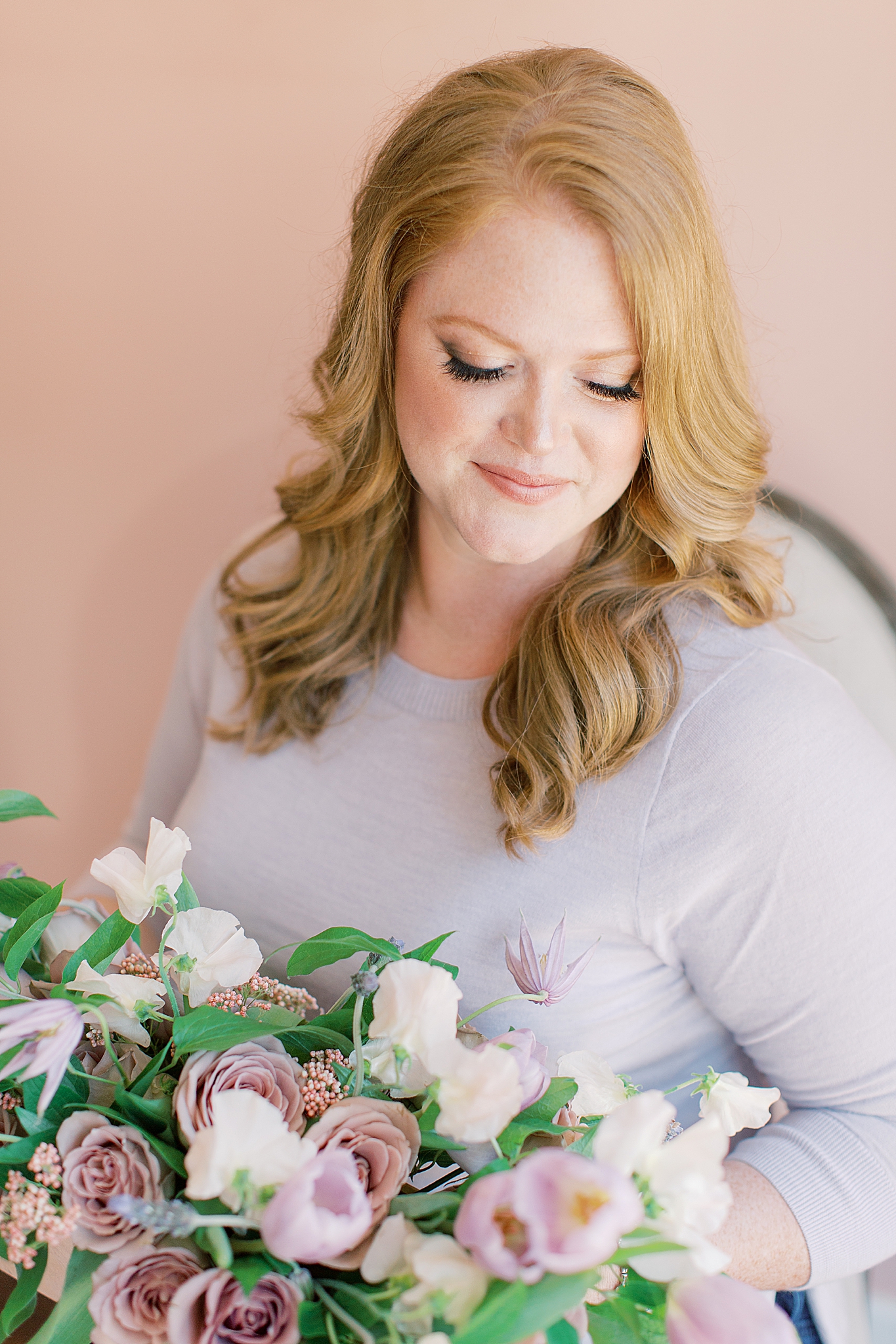 Branding portraits of wedding planner looking at bouquet