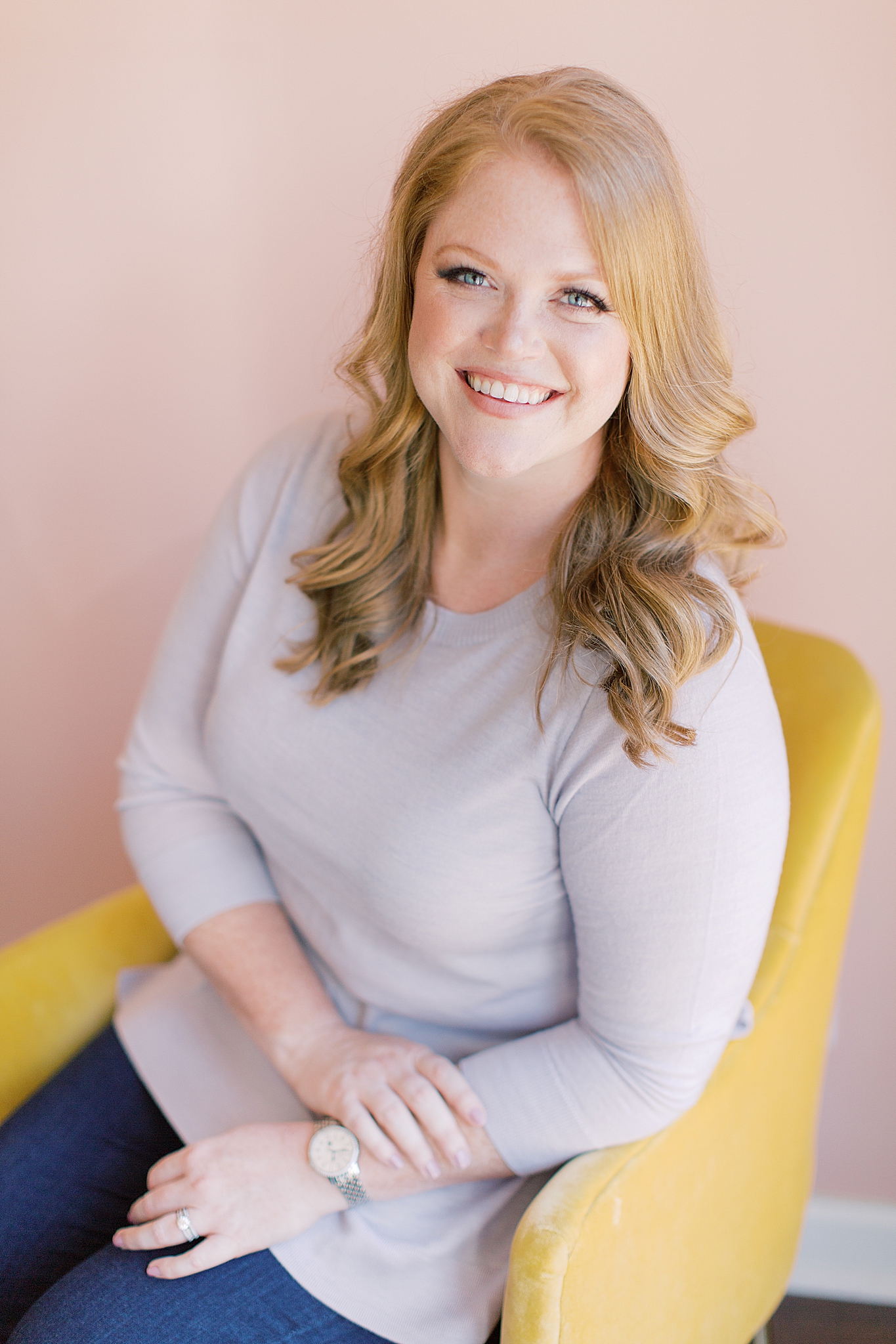 wedding planner sits in yellow chair during branding session