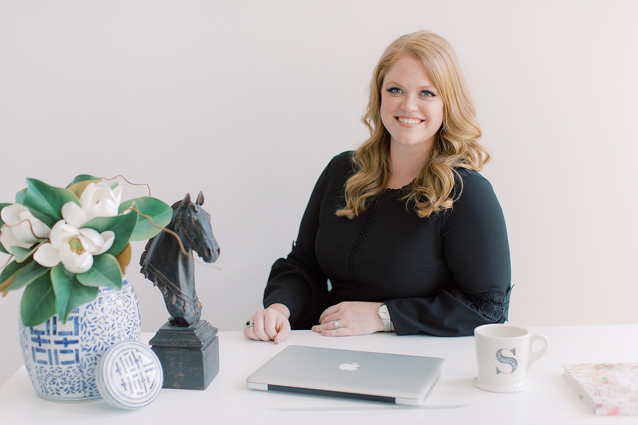wedding planner sits at desk during session with Charlotte branding photographer