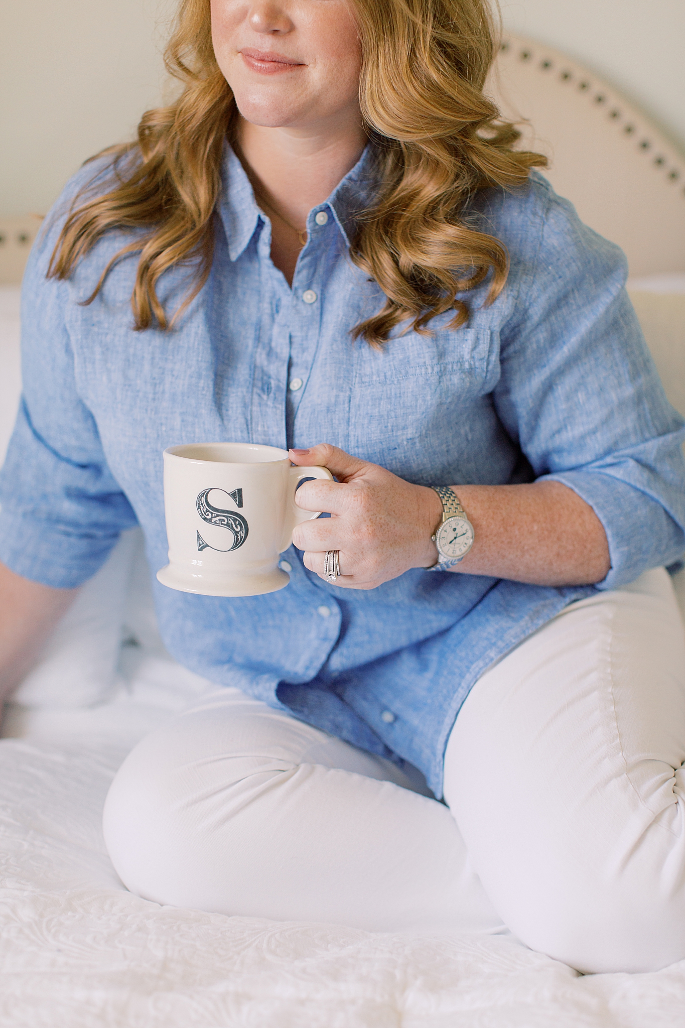 woman holds coffee mug with S on it