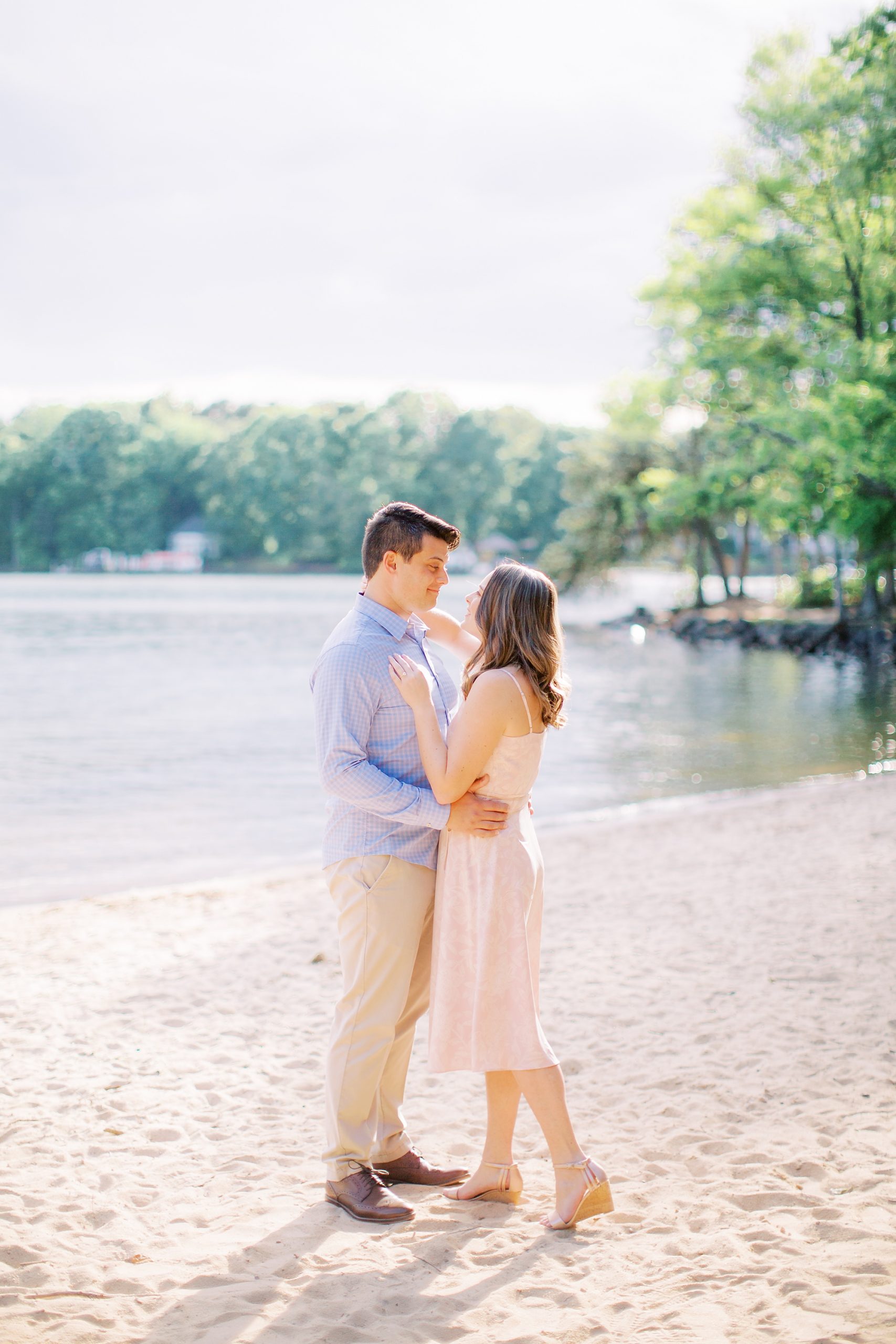 bride and groom stand on beach together at Lake Norman