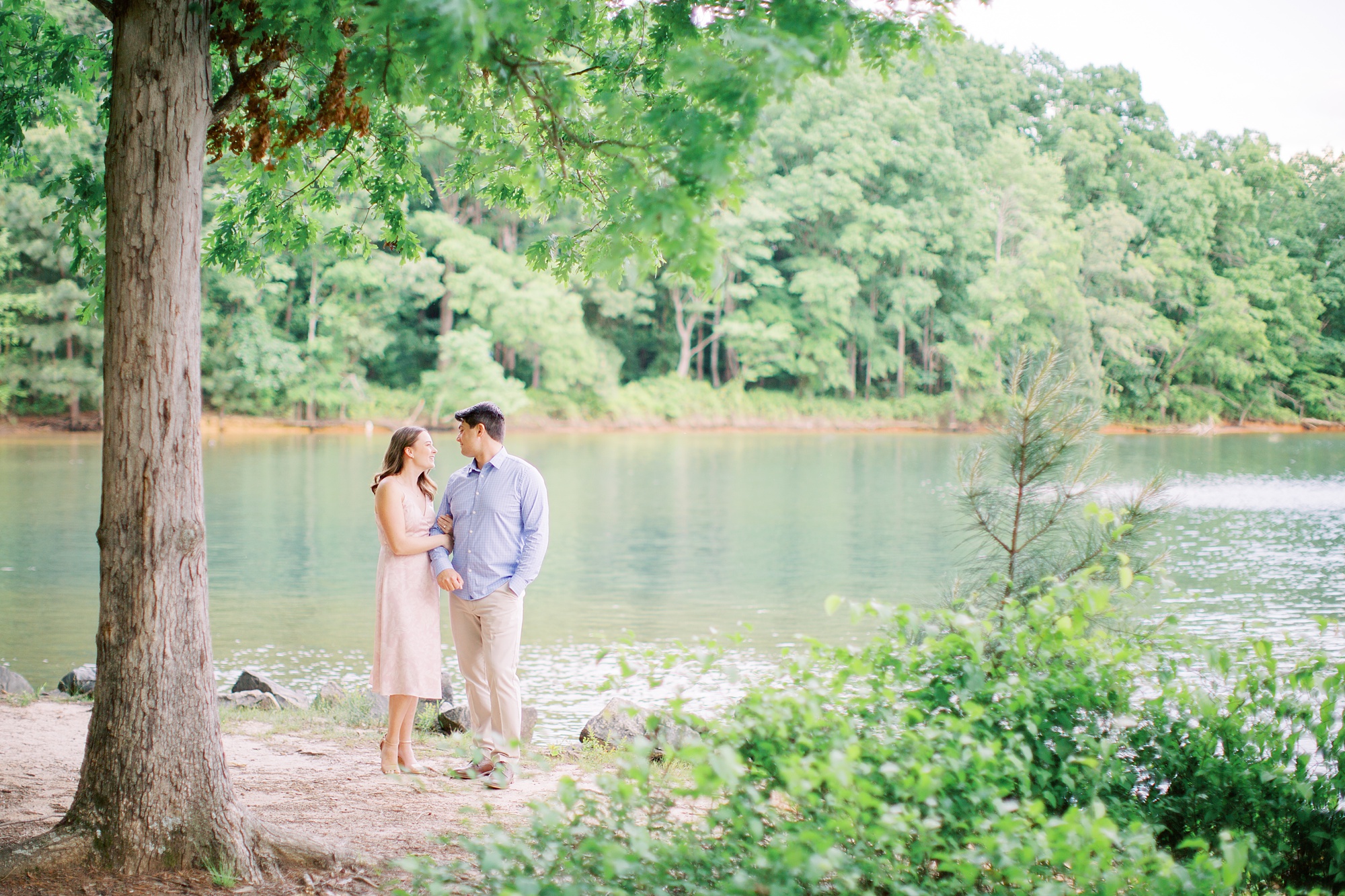 bride and groom stand on beach at Lake Norman