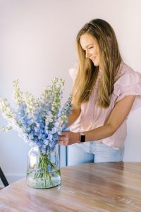 designer adjusts flowers in kitchen during Charlotte branding session