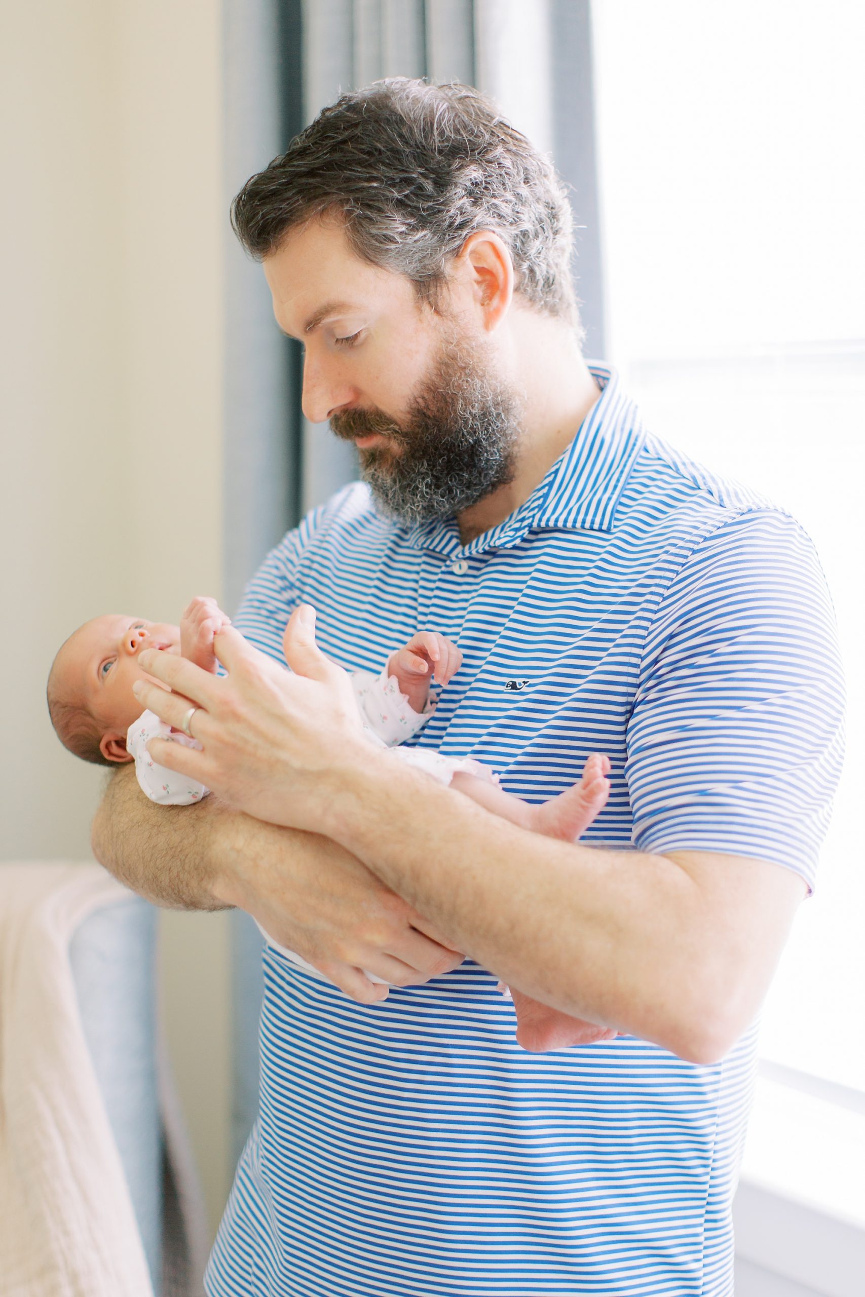 dad holds baby girl during newborn photos