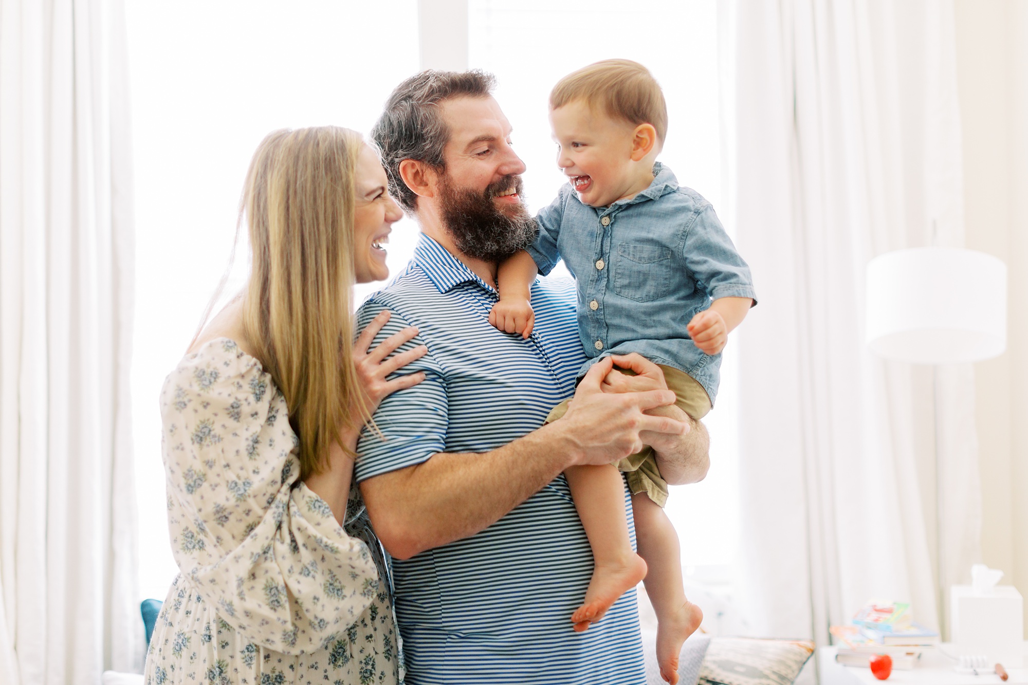 mom and dad hold son during lifestyle photos at home