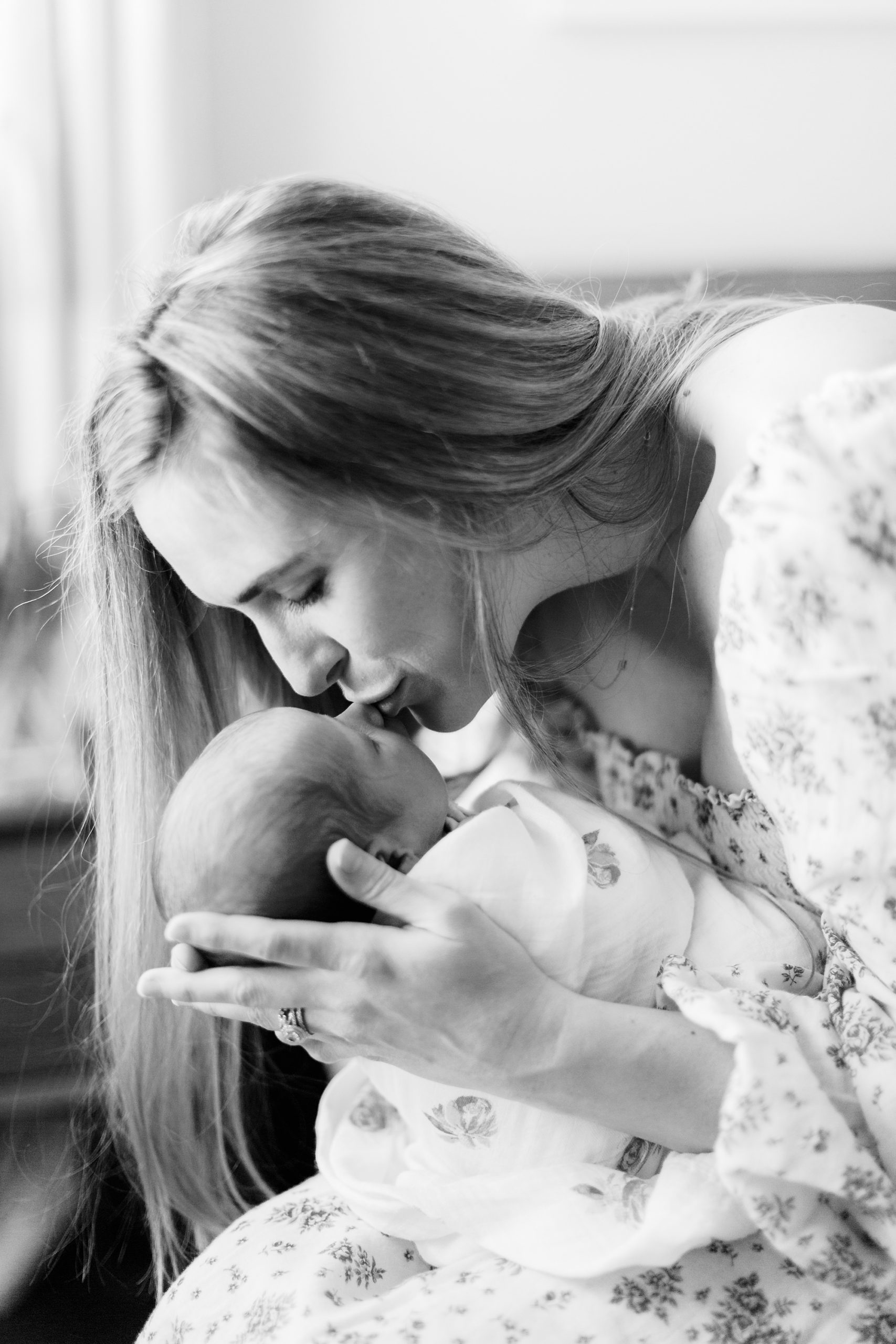 mom kisses daughter during Charlotte newborn photos