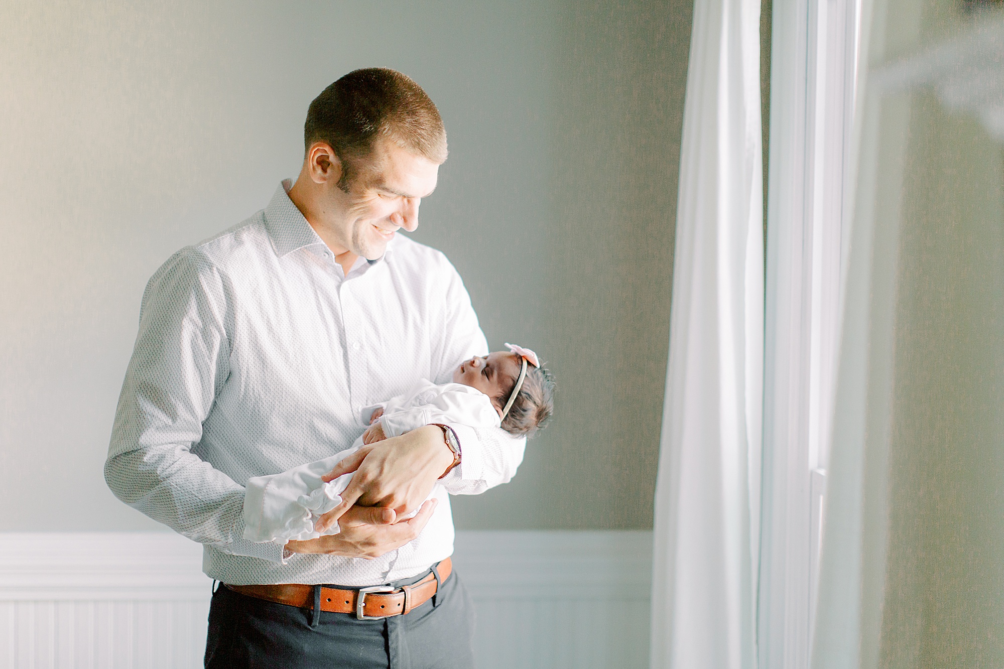 dad holds baby girl during Charlotte newborn session
