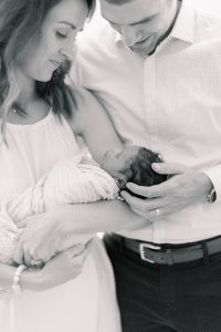 parents snuggle with daughter during Charlotte newborn session