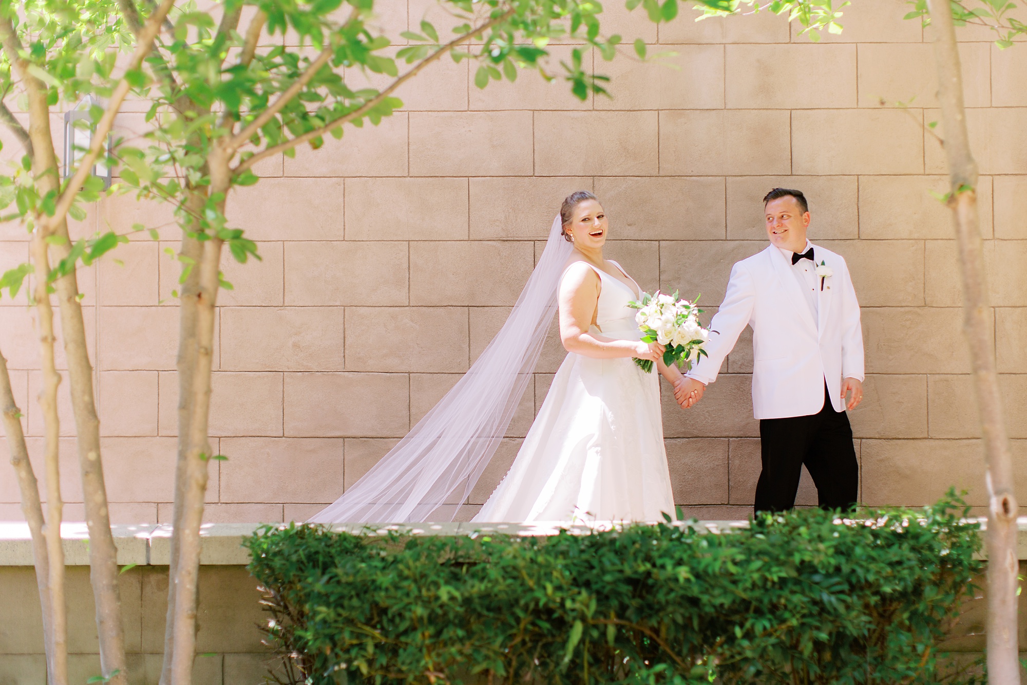 bride and groom walk along patio of Charlotte church