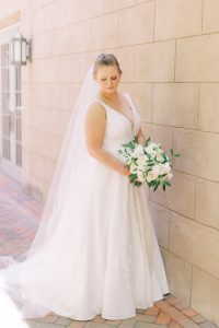 bride holds bouquet and looks over shoulder