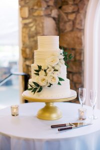 tiered wedding cake rests on gold stand