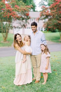 parents laugh with daughters in front yard during Charlotte family session