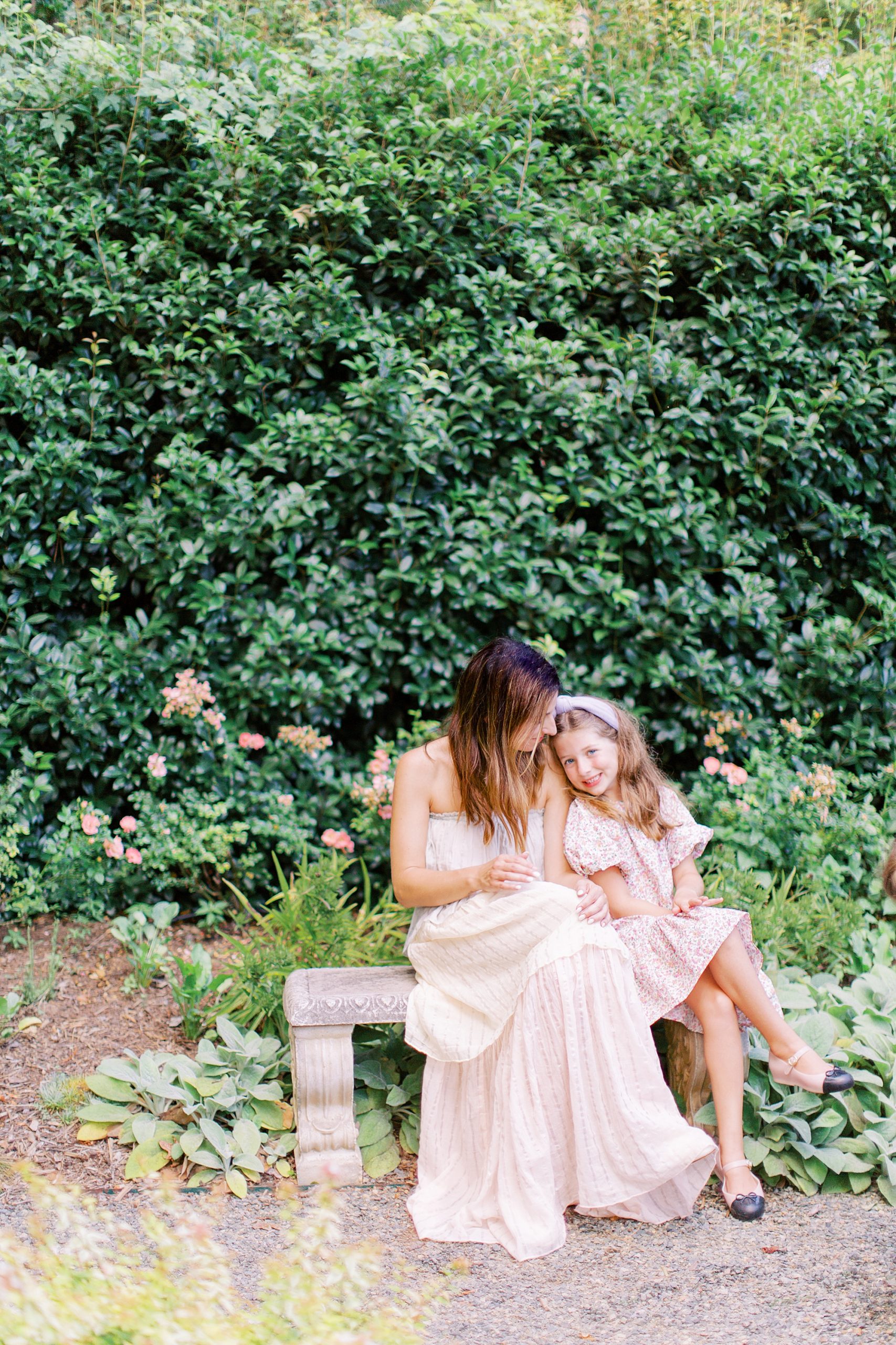 mom sits with daughter on bench during family photos in Charlotte NC