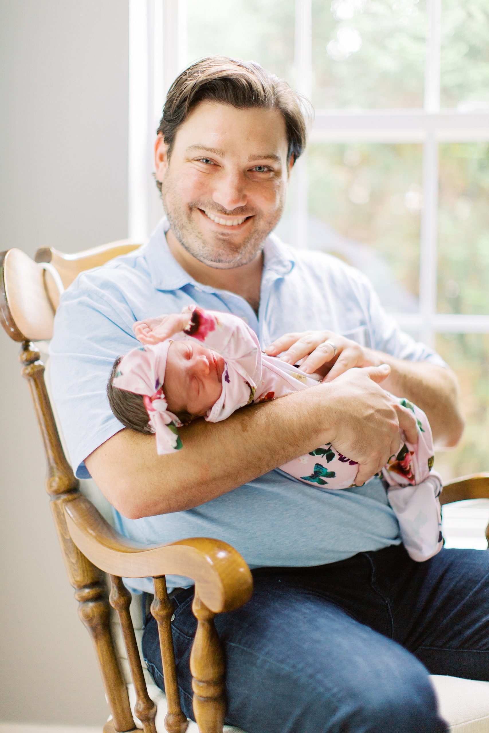 dad holds daughter in floral wrap photographed by Charlotte Newborn Photographer Demi Mabry