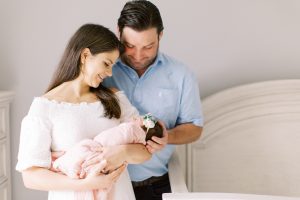 parents look at baby girl during newborn photos in Charlotte NC