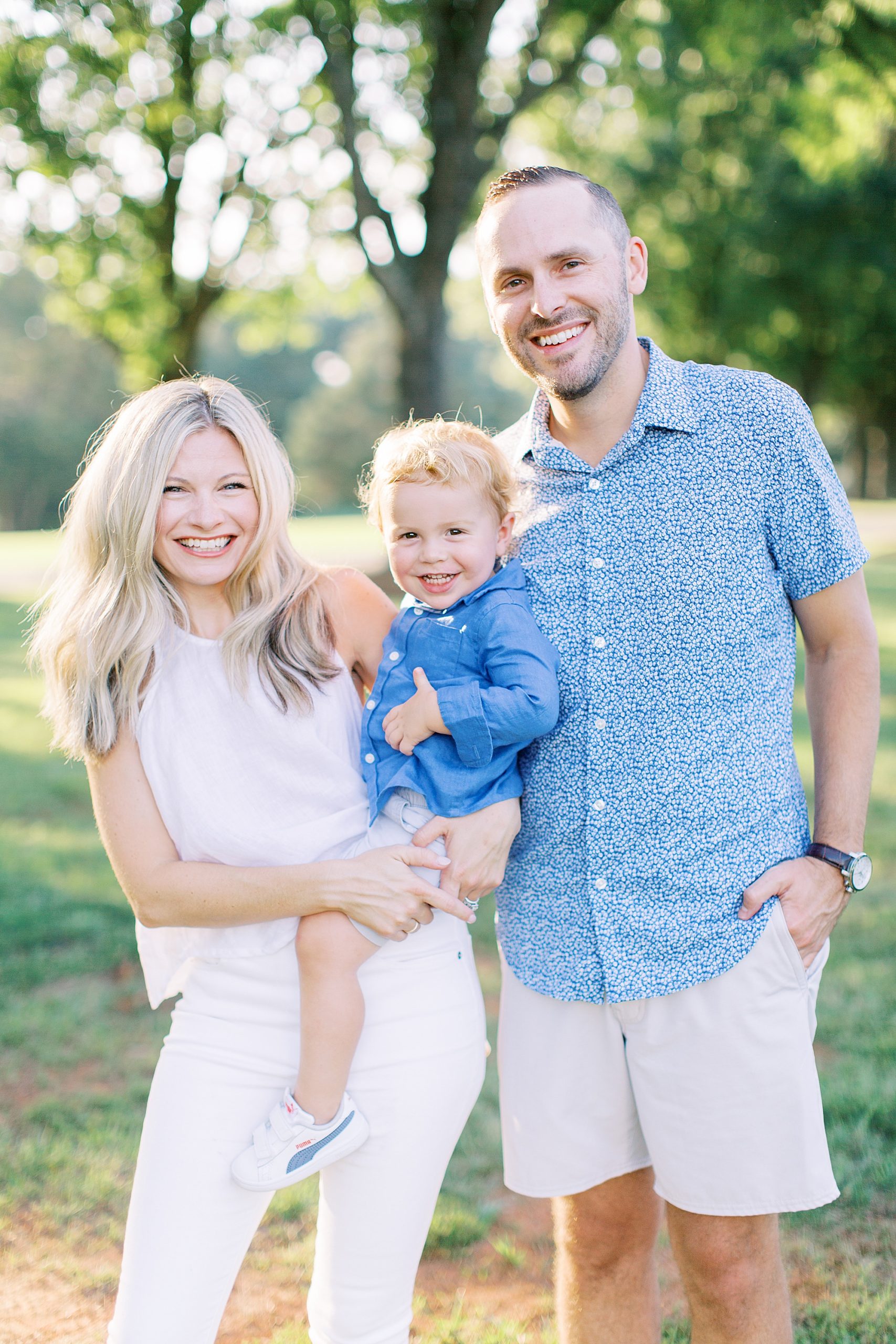 parents smile with son during family photos at Cabarrus Country Club