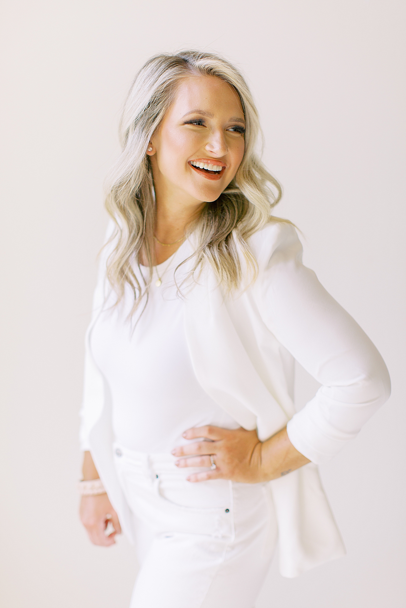 woman in white jacket smiles during branding photos