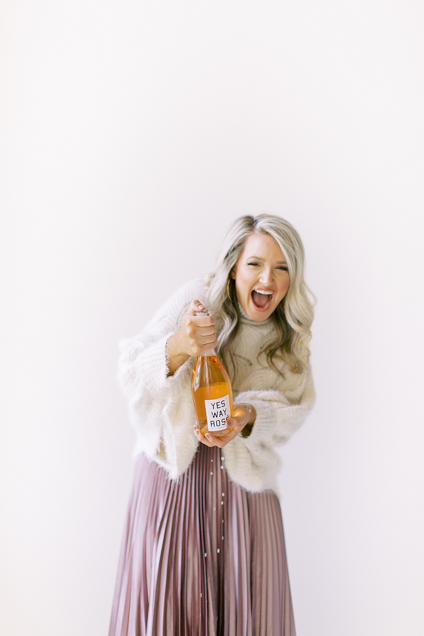 business owner laughs holding champagne