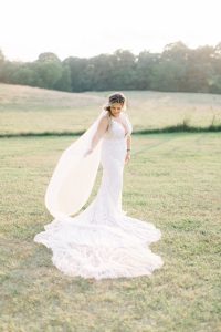 bride holds veil behind her during bridal portraits at The Dairy Barn