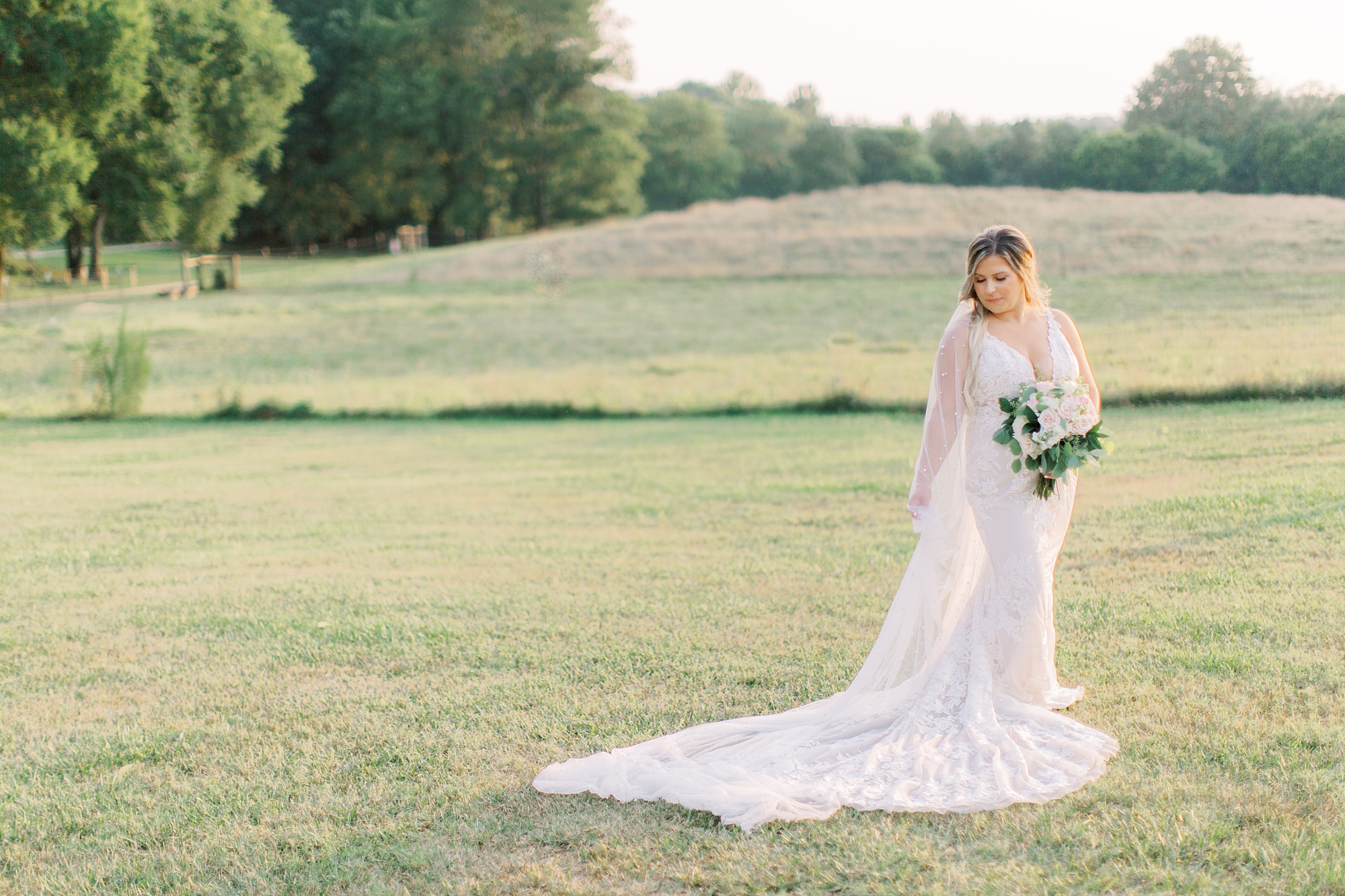 bride looks over shoulder at wedding gown