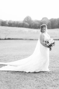 bride holds bouquet looking over shoulder at The Dairy Barn