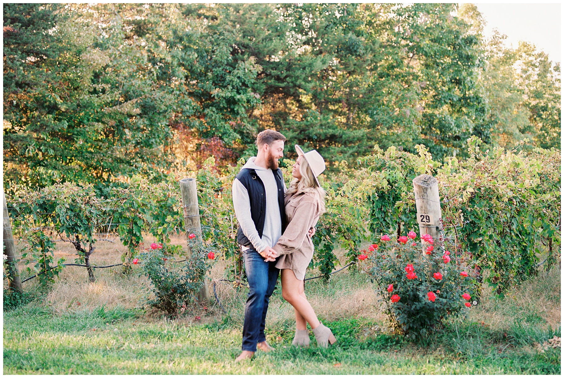 engaged couple stands by vines at Raffaldini Vineyards