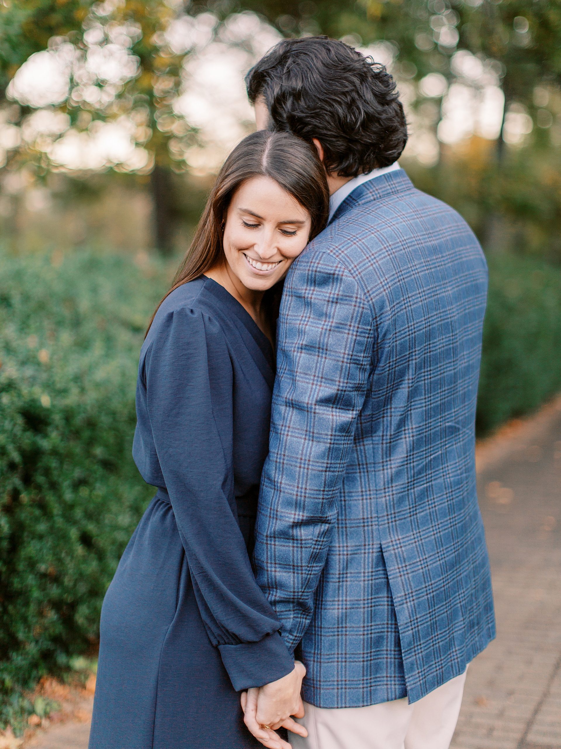 bride leans on groom's shoulder during fall Mint Museum engagement session