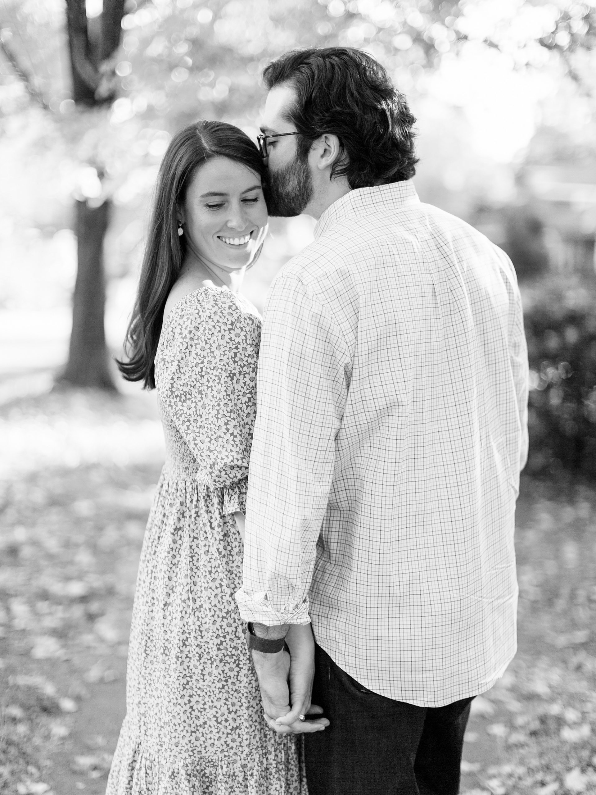 groom holds hands with fiancee and kisses her forehead during NC engagement photos