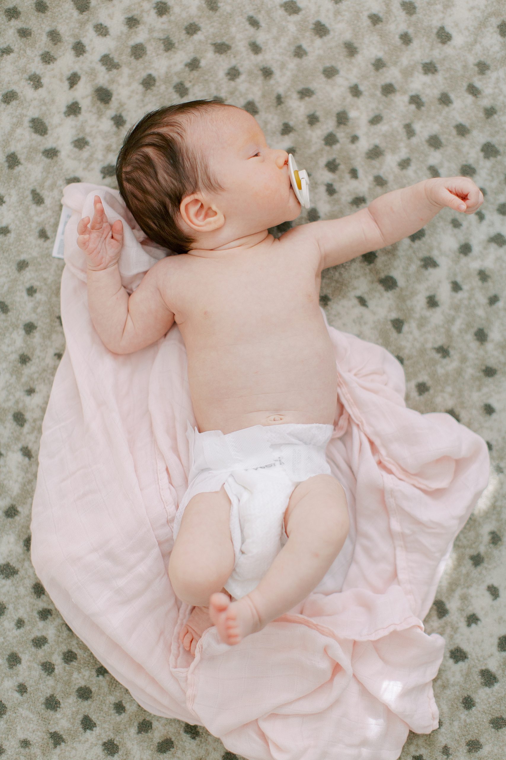 baby girl sleeps on rug during newborn portraits
