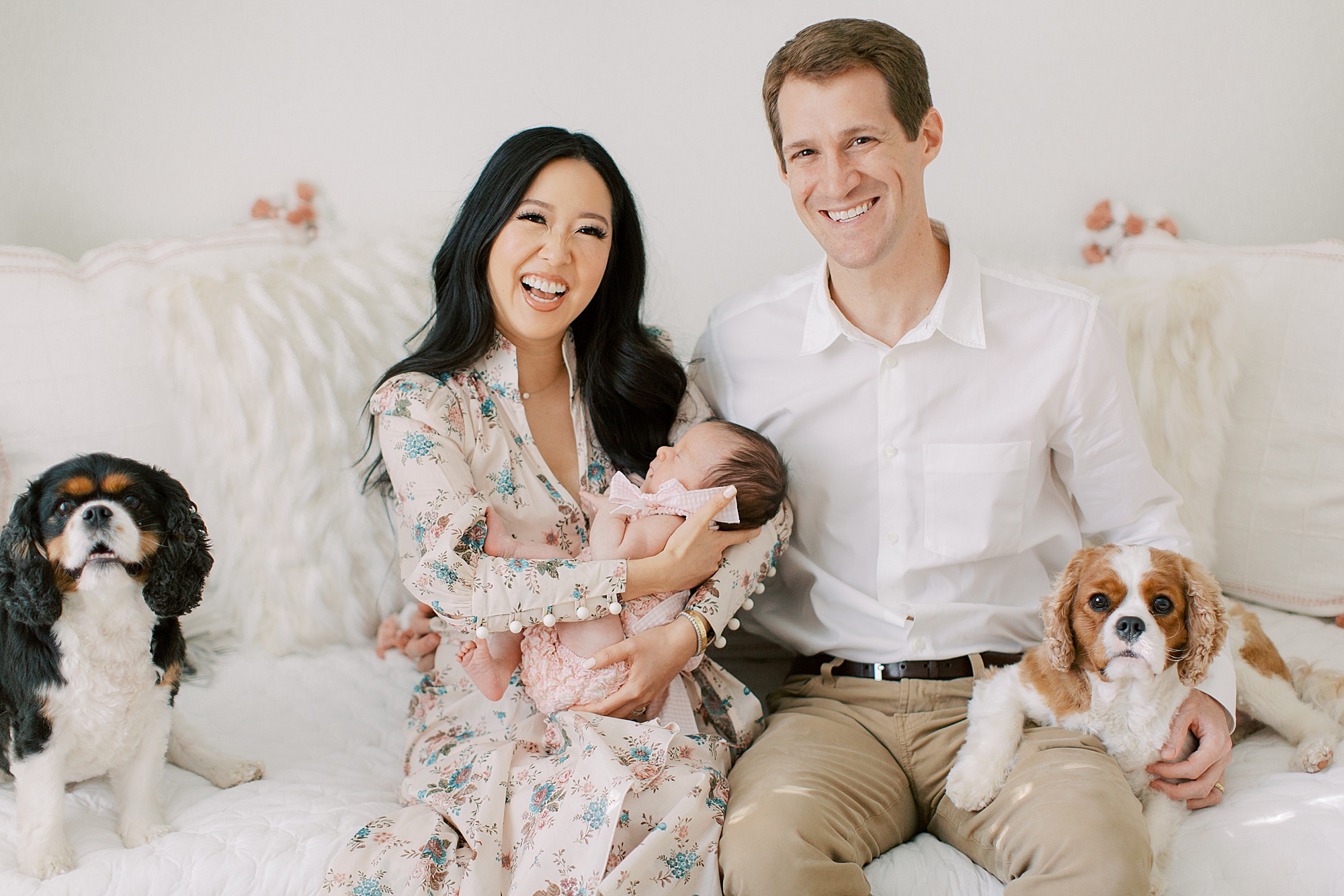 parents pose with dogs and baby girl