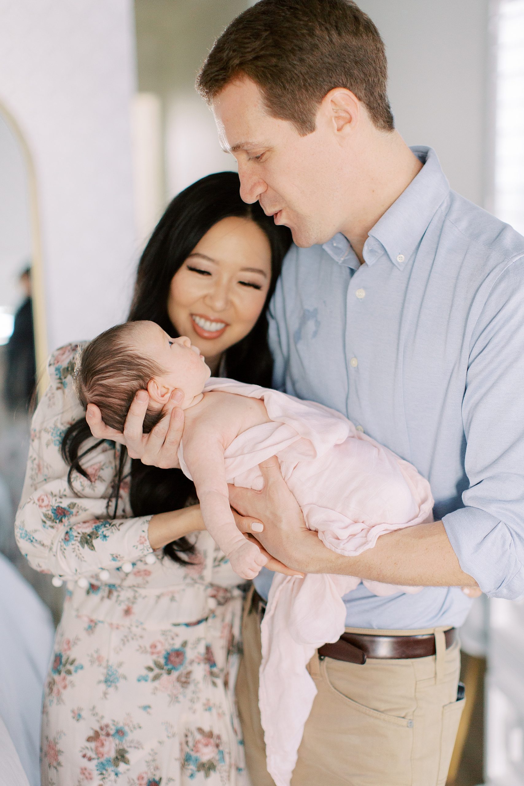 parents admire baby girl in nursery during at-home newborn portraits