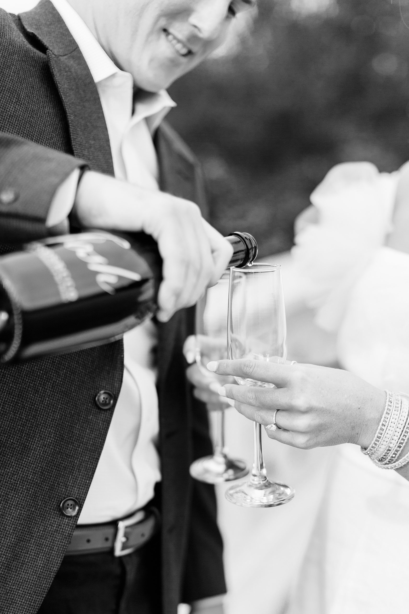groom pours champagne for bride during Midtown Park engagement session