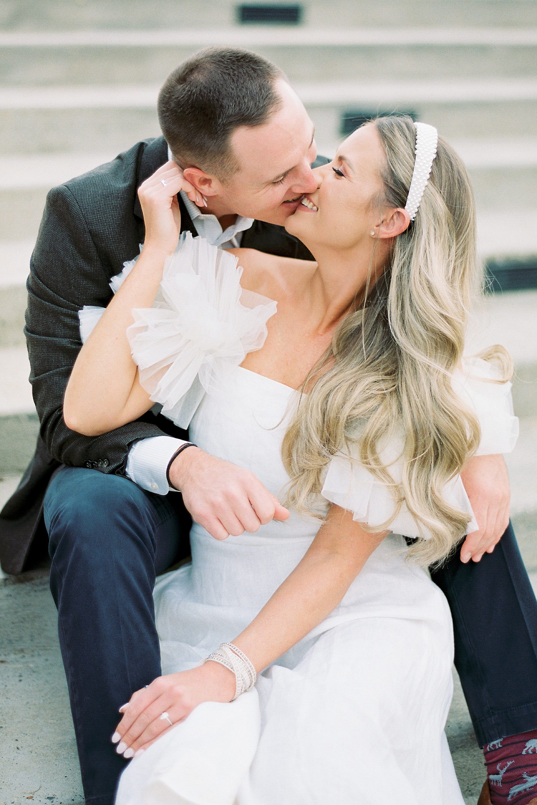 bride and groom kiss on steps during Midtown Park engagement session