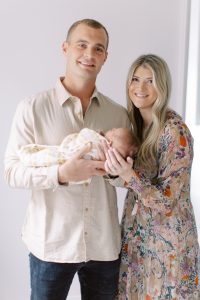 parents hold baby girl during newborn photos