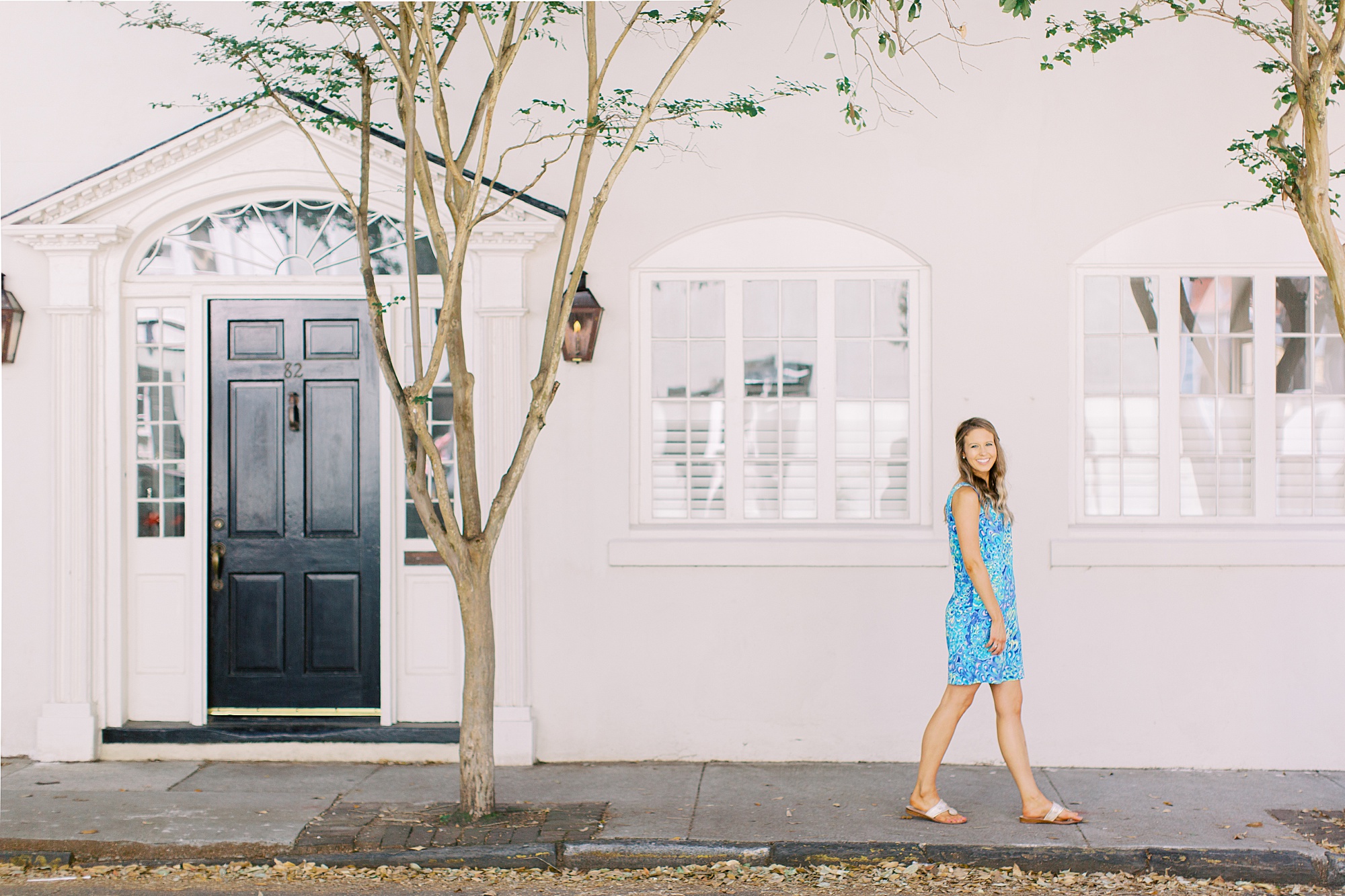 woman walks by pink house in Downtown Charleston