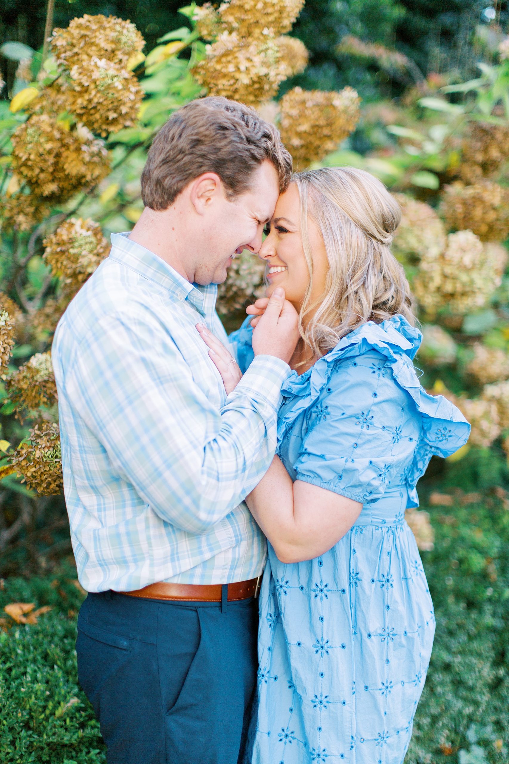 couple poses together in gardens during Duke Mansion engagement photos