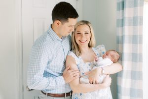 new parents hold son in nursery during lifestyle newborn session