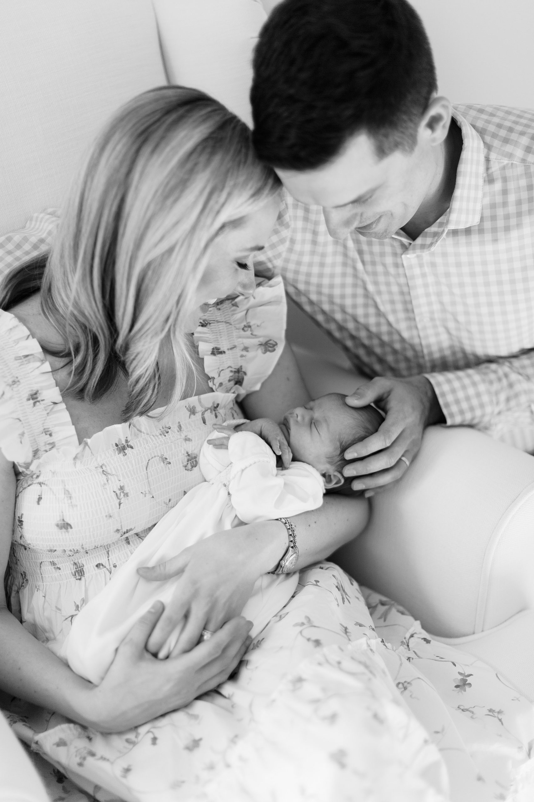 black and white portrait of new parents holding son