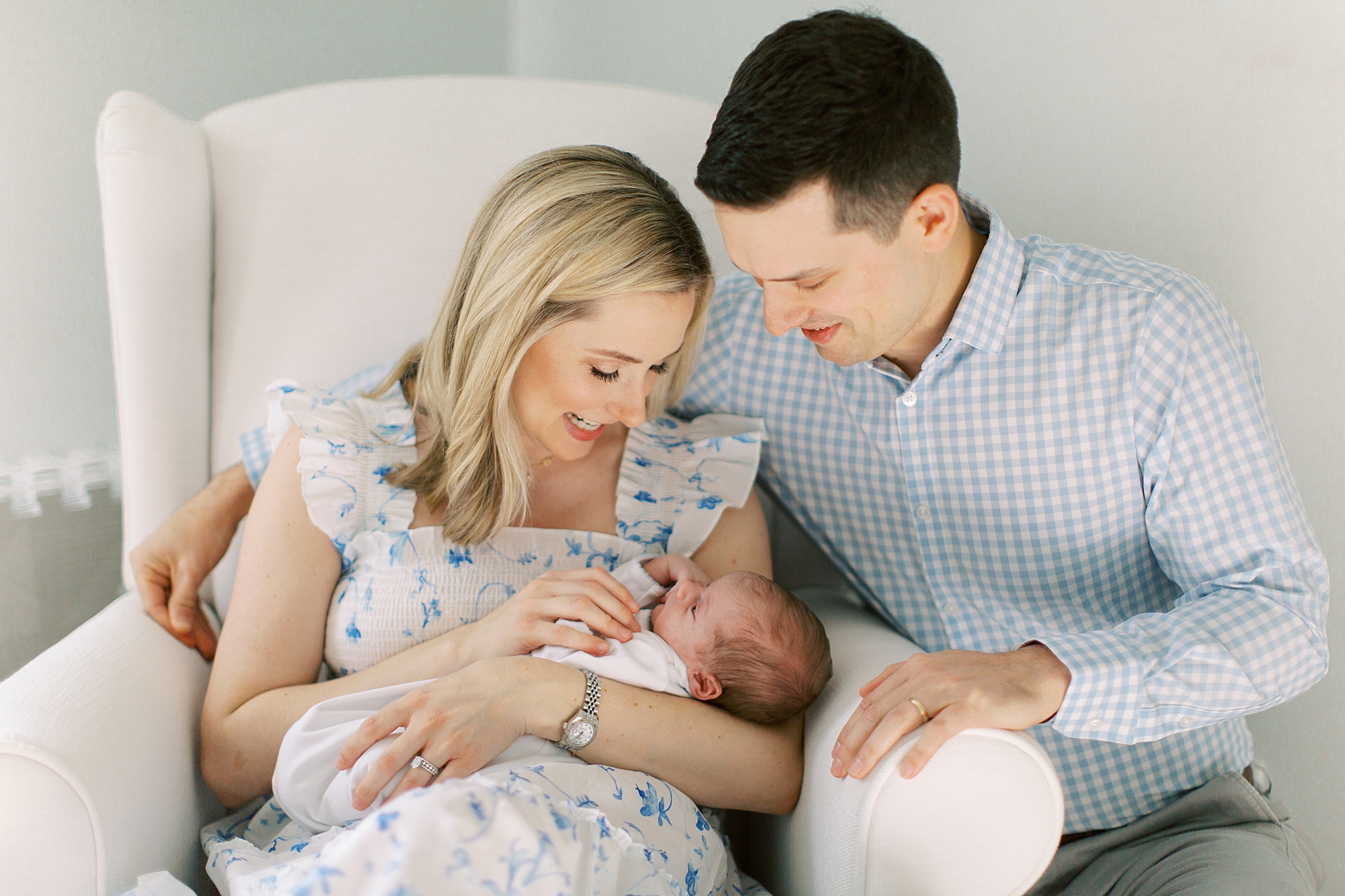 new parents look at baby boy during newborn photos at home