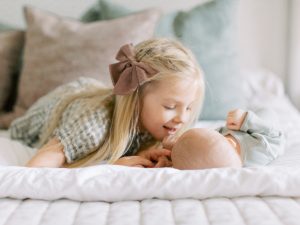 girl kisses baby brother during Charleston SC newborn session