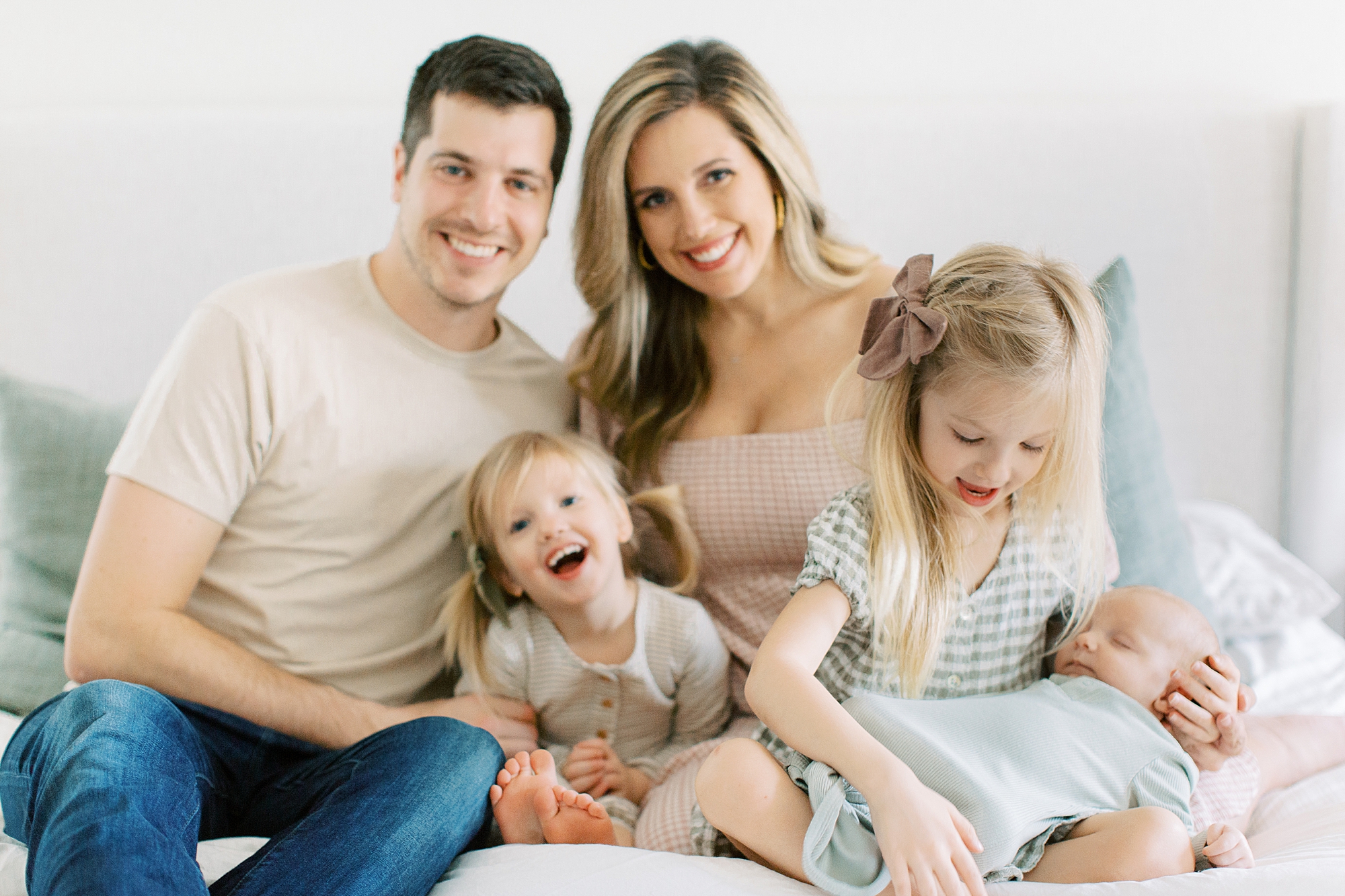 family of five sits on bed during Charleston SC newborn session
