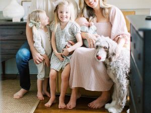 mom poses with three kids and dog at home